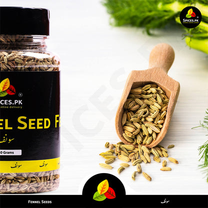 Organic fennel seeds in a wooden scoop next to the 140g product jar, highlighting the natural aroma and quality of Spices.pk spices.