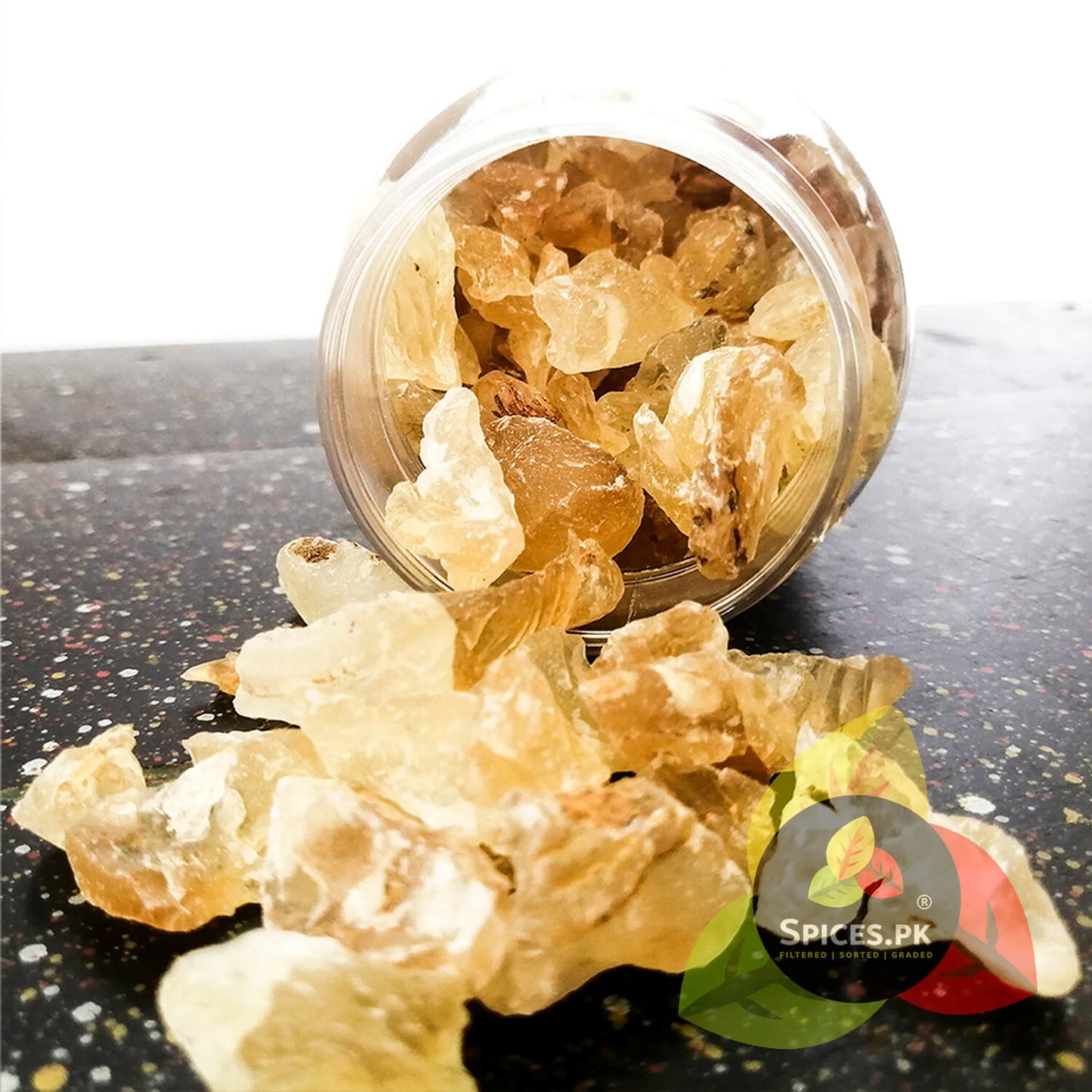Raw crystal pieces of edible Tragacanth Gum spilling out from a premium Spices.pk plastic container.