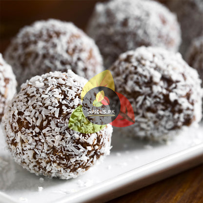Traditional white coconut laddoos served in a bowl alongside a Spices.pk Giri Burada 150g jar for dessert recipes.Chocolate truffles with coconut shavings on a white plate, branded with 'Spices.PK'.