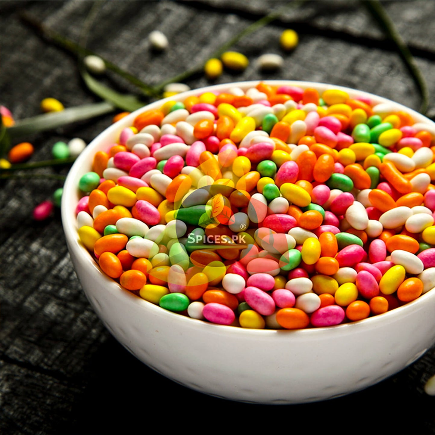 White bowl full of premium colorful sugar coated fennel seeds on a rustic background. Buy fresh Meethi Saunf online in Pakistan.