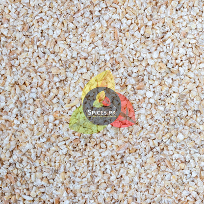 Detailed macro texture background shot of raw, dust-filtered crushed barley daliya grains from Spices.pk.
