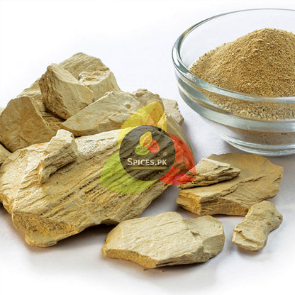 Pure Multani Mitti stones placed next to fine Fuller's earth powder in a clear glass bowl for face mask preparation.