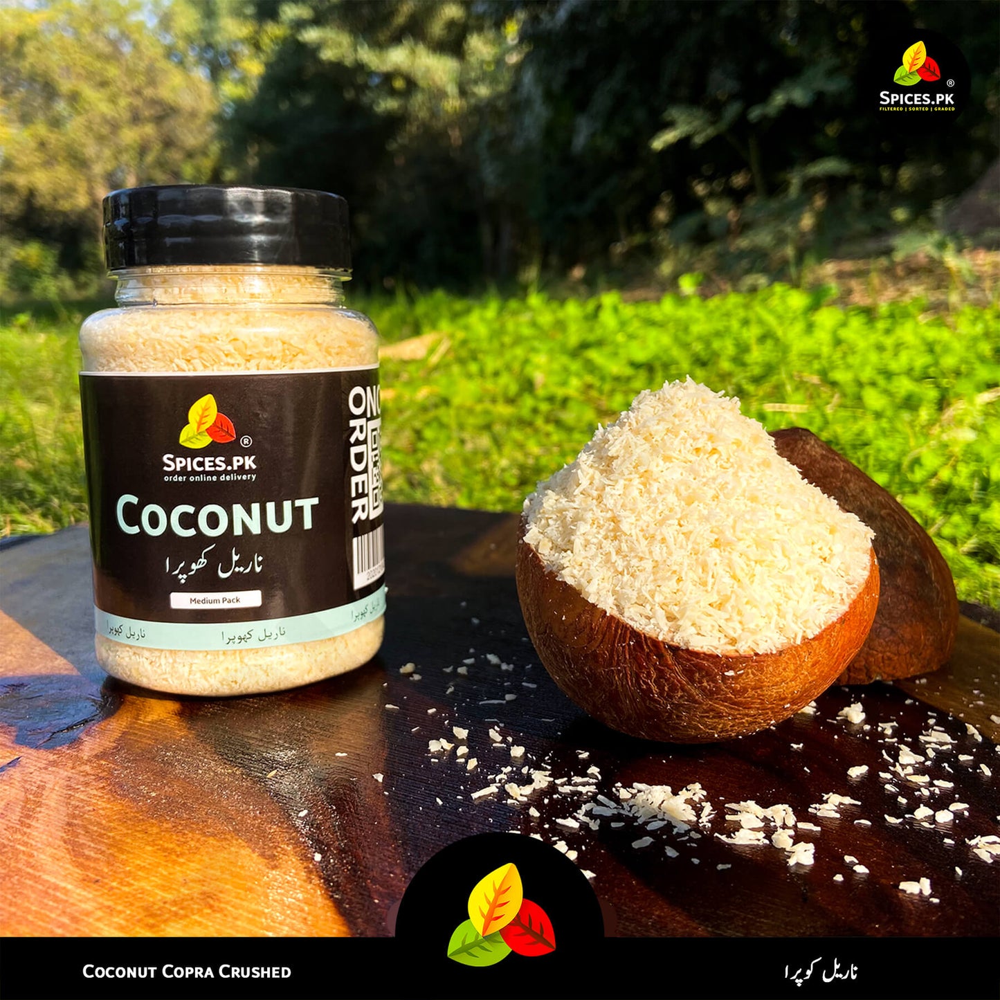 Spices.pk Khopra Crush jar displayed outdoors, emphasizing hand-sorted, chemical-free, organic shredded coconut.Jar of coconut copra crushed and a half-coconut with coconut pieces on a wooden surface outdoors.
