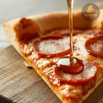 Spicy pepperoni pizza slice being drizzled with sweet, aromatic mace-infused hot honey featuring Spices.pk Javitri.