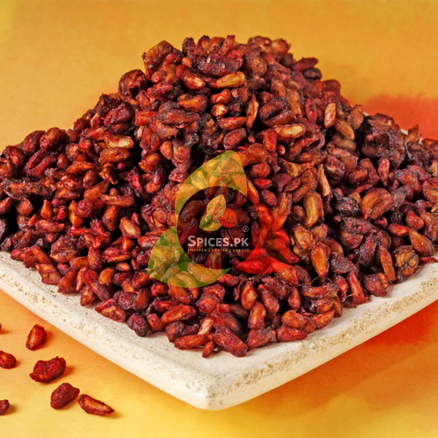 Pile of dried red chilies on a white plate with 'Spices.PK' logo.Spices.pk Premium Dry Pomegranate Seeds (Anardana); 100% sun-dried, naturally sour, and high-quality spice for authentic Pakistani cooking.