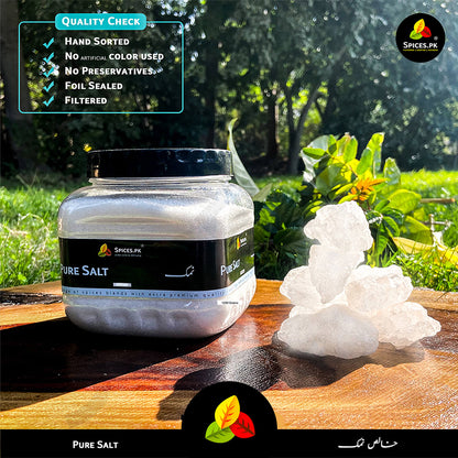 Jar of pure salt on a wooden surface with natural background.Premium Pure Salt 1200g jar, hand-sorted and filtered natural Namak by Spices.pk.