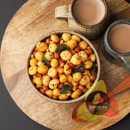 Bowl of roasted chickpeas with a cup of tea on a wooden board, featuring the Spices.PK logo.Top-grade pure desi phool makhana (پھول مکھانہ) available for online delivery across Pakistan from Spices.pk.