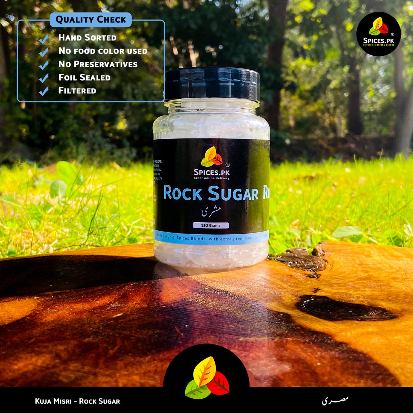 Hand-sorted Kuja Mishri by Spices.pk displayed outdoors. 100% natural rock sugar with no food color or preservatives.Spices.PK rock sugar jar on a wooden surface with greenery in the background