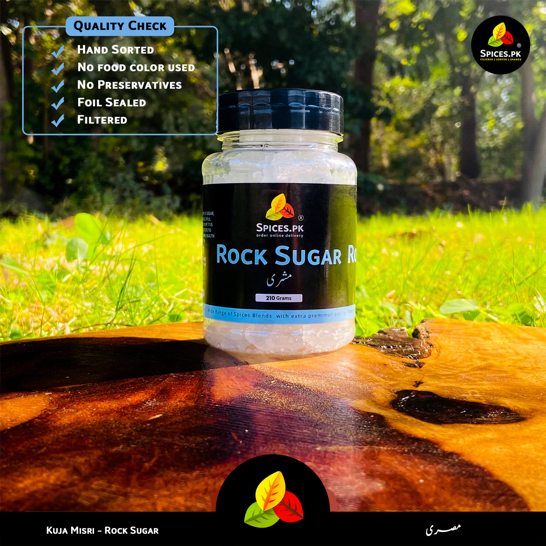 Hand-sorted Kuja Mishri by Spices.pk displayed outdoors. 100% natural rock sugar with no food color or preservatives.Spices.PK rock sugar jar on a wooden surface with greenery in the background