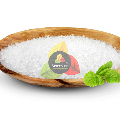 Pure white food grade Tatri crystals or Nimbu Sat in a wooden bowl with green mint garnish, showcasing high quality citric acid.