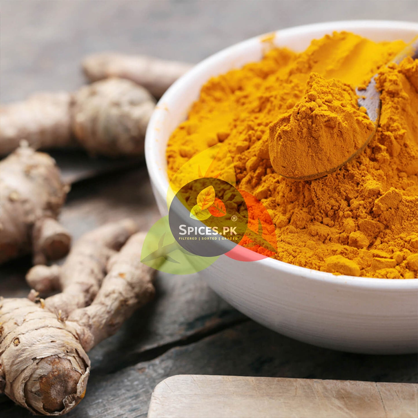 Pure Turmeric Powder (Haldi) in a bowl with fresh raw turmeric rhizomes – Premium quality from Spices.pk.