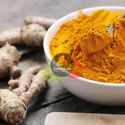 Pure Turmeric Powder (Haldi) in a bowl with fresh raw turmeric rhizomes – Premium quality from Spices.pk.