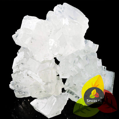 Sparkling white, unrefined raw rock sugar crystals. Premium uncolored Kuja Mishri chunks on a clean black background.Crystal rock on a black background with 'Spices PK' logo.