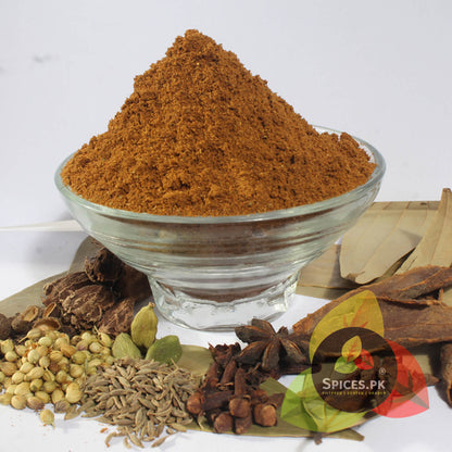 Garam Masala Powder served in a glass bowl surrounded by its raw whole spice ingredients like star anise and coriander. Spices.pk ensures premium quality, hand-sorted, and foil-sealed freshness.