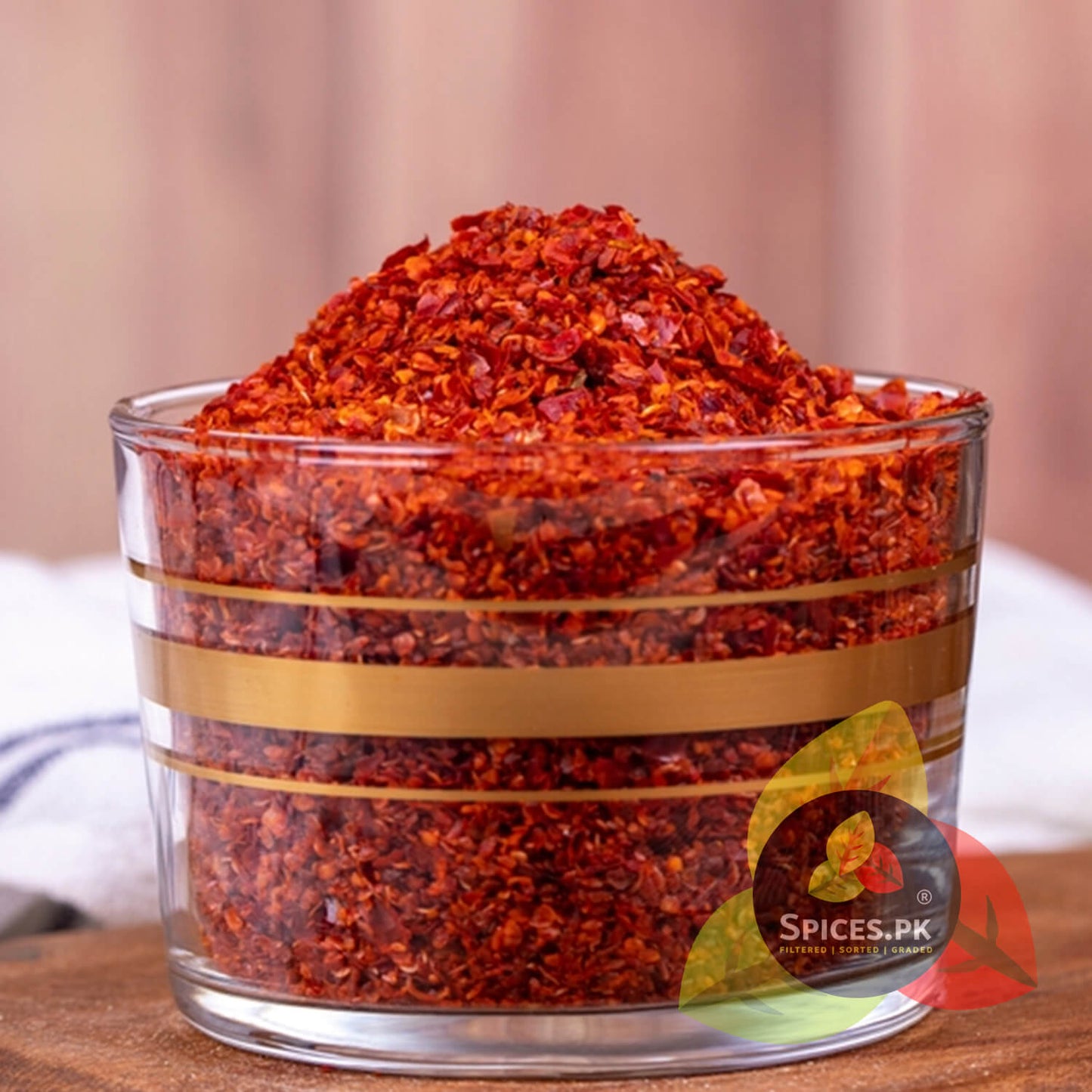 Rich, vibrant Red Chilli Flakes piled high in a glass bowl, showcasing the natural texture and color of Spices.pk seasonings.